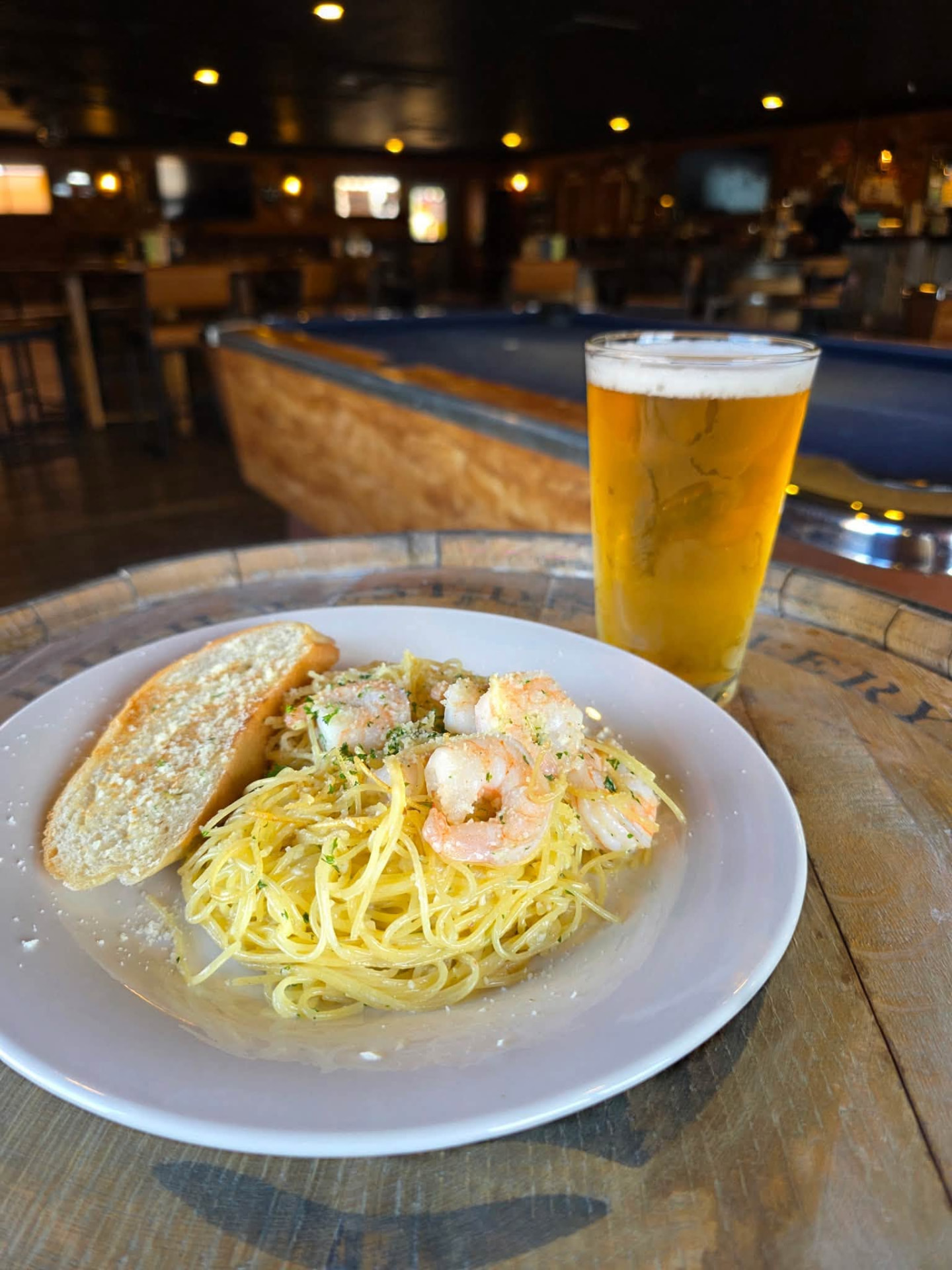 Shrimp scampi with garlic bread and a cold beer at the bar