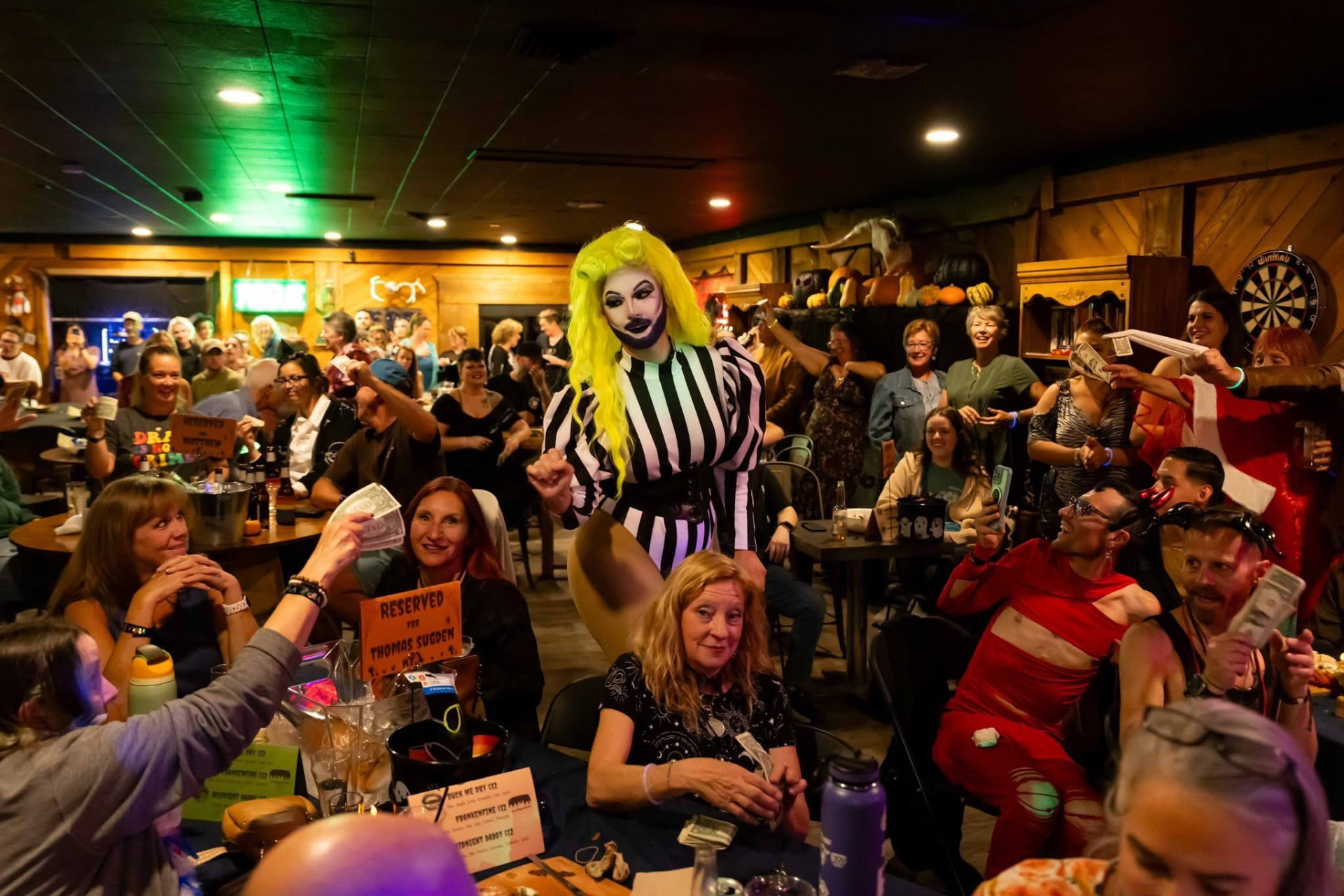Packed crowd cheering at a drag show inside the tavern