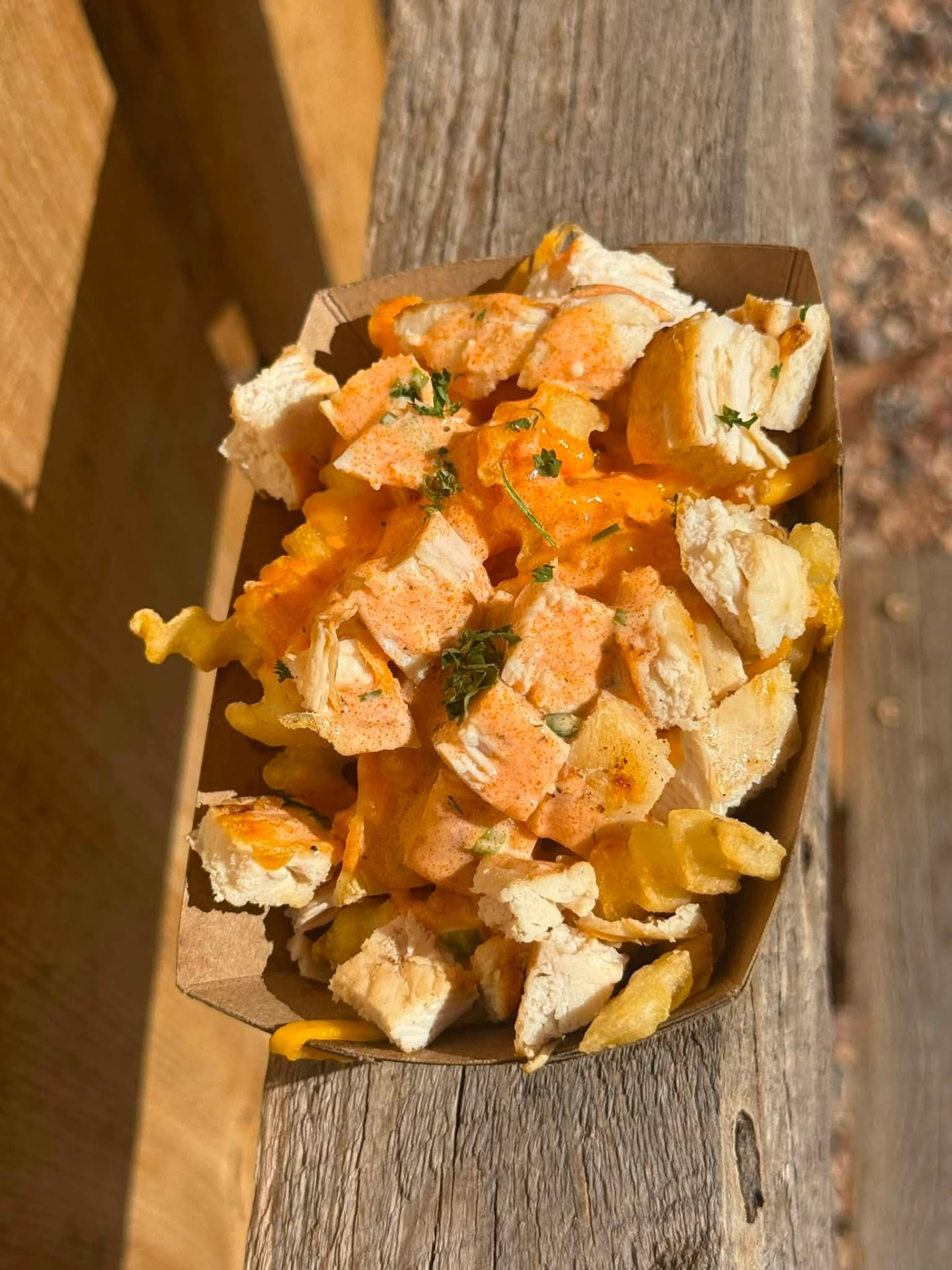 Buffalo chicken loaded fries in a paper tray